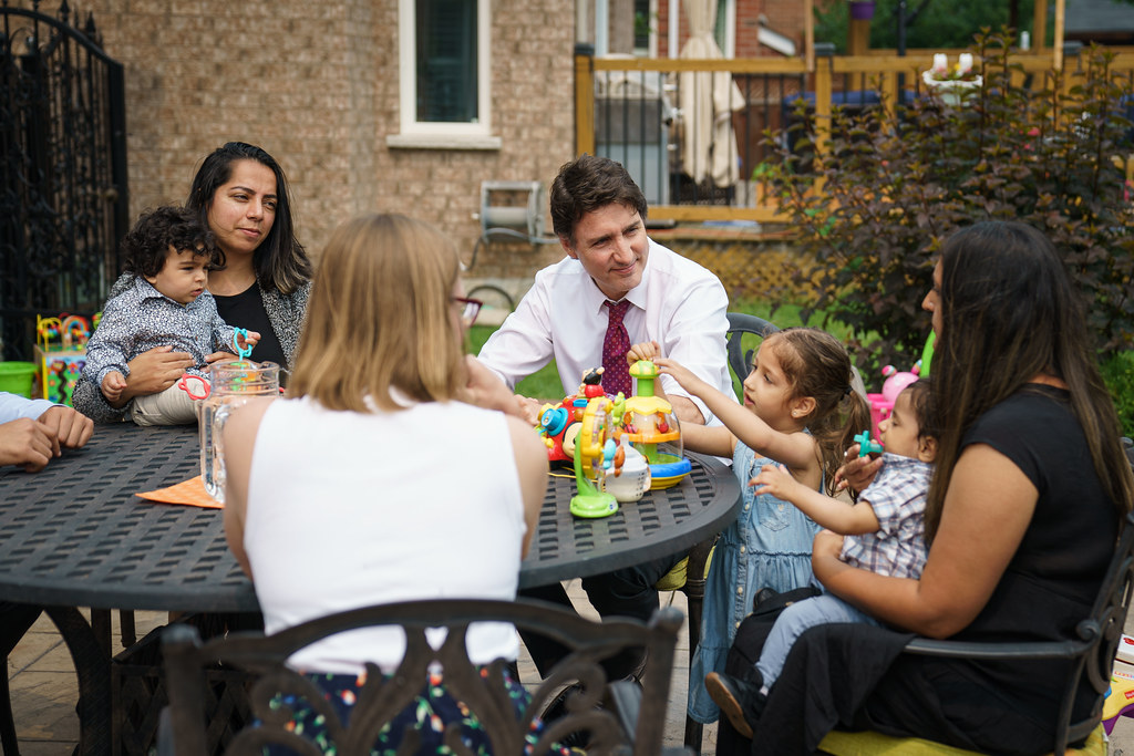 PM Justin Trudeau sitting at a table with families