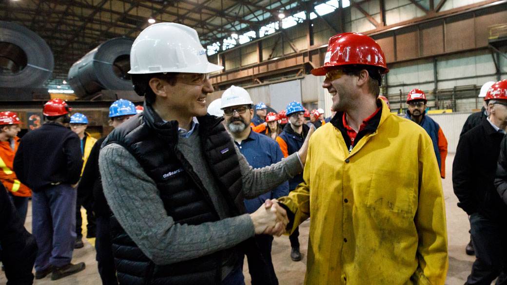Prime Minister Justin Trudeau shakes hands with a steel worker at a factory in Sault Ste. Marie, Ontario