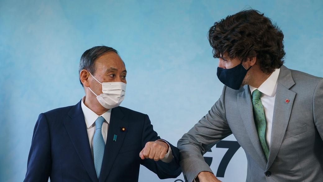 Prime Minister Justin Trudeau bumps elbows with Prime Minister Suga Yoshihide at the G7 Leaders' Summit.