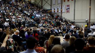 Prime Minister Justin Trudeau addresses the crowd during a town hall discussion in a gymnasium.