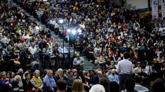 Prime Minister Justin Trudeau takes questions from the audience during a town hall discussion in a gymnasium.