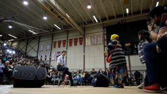 Le premier ministre Justin Trudeau prend une question du public lors d'une discussion publique tenue dans un gymnase.