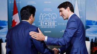 Prime Minister Justin Trudeau shakes hands with PM Shinzo Abe.
