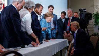 Chancellor Merkel talks to President Trump in front of the G7 Leaders.