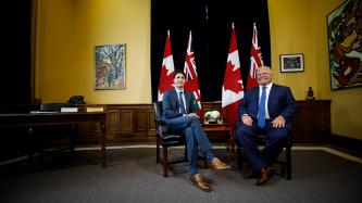 Prime Minister Justin Trudeau sits with Ontario Premier Doug Ford.