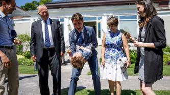 PM Trudeau plays with a small boy while family looks on