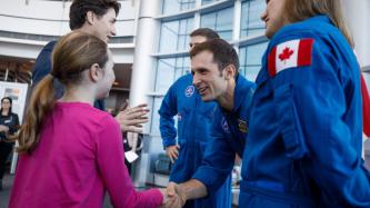 Ella-Grace shakes hands with astronaut Joshua Kutryk