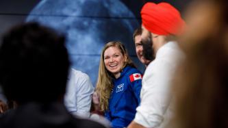 L’astronaute Jenni Sidey sourit pendant que le min. Bains parle