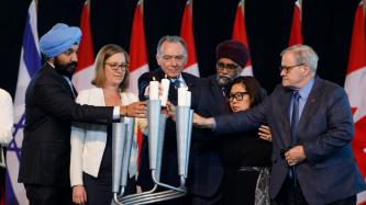 Ministers Bains, Gould, Sajjan, Ng, and MacAulay and MP Kent place a candle in a holder