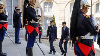 President Macron and PM Trudeau walk up steps among the Republican Guard