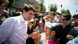 PM Trudeau speaks with a girl in a crowd