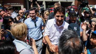 PM Trudeau shakes hands with a crowd member