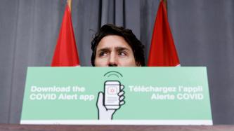 PM Trudeau behind a COVID Alert podium card