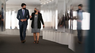 Prime Minister Justin Trudeau and Ms. Mary Simon walk in a corridor