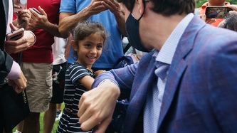 PM Justin Trudeau bumps elbows with a young girl