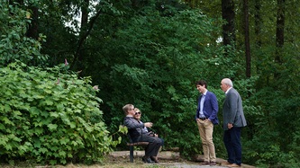 Les PMs Trudeau et Horgan discutent avec un couple assis sur un banc de parc