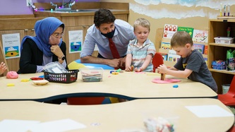 Le PM Trudeau regarde des enfants jouer à une table