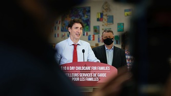 Vue du PM Trudeau devant un lutrin et du PM King derrière lui à travers la foule.