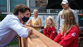 PM Trudeau looks at kids at an outdoor patio area