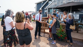 People are gathered near PM Trudeau near an outdoor patio