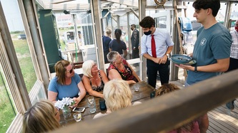 PM Trudeau stands near people seated at a table at an eatery