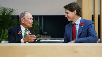 Michael Bloomberg et le PM Trudeau se regardent, assis à une table