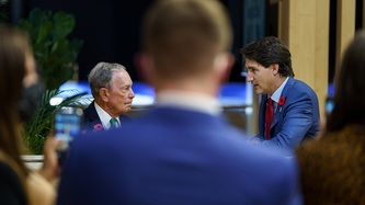 Michael Bloomberg et le PM Trudeau sont à l’avant-scène, sous le regard d’autres personnes