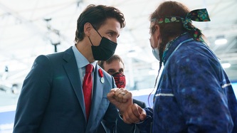 Le premier ministre Justin Trudeau salue un homme d’un coup de coude