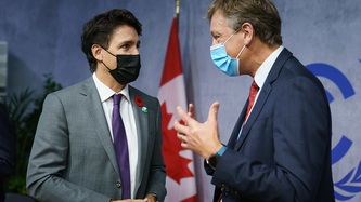 Le premier ministre Justin Trudeau regarde un homme qui fait des gestes de la main