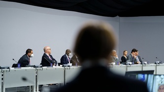 Des gens sont assis à une table devant des microphones