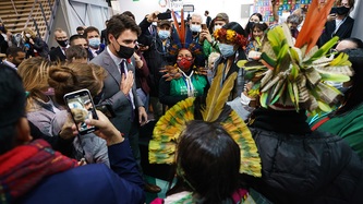 Le premier ministre Justin Trudeau regarde une foule de personnes et de caméras