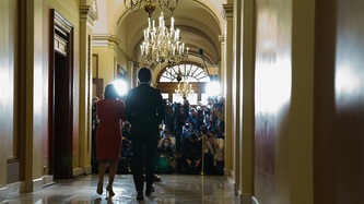 Prime Minister Trudeau and Deputy Prime Minister Freeland walk towards photographers in a hallway