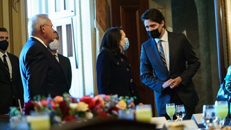 Prime Minister Trudeau leans towards a woman with others near a table