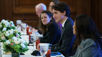 PM Trudeau, DPM Freeland, and Minister Ng look on seated at a table